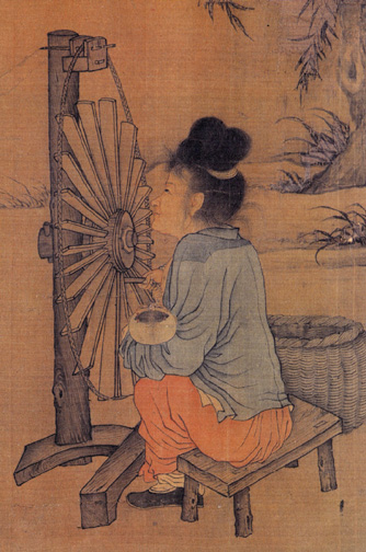 The image pictured as a tapestry-esque look to it. There is a woman pictured at a side view sitting on a wooden bench with a spinning wheel infront of her. She is holding a ball of yarn, which she places into the spinning wheel to make cloth which can be used for clothing. She is sitting by herself and what looks to be the outdoors because of the size of the spinning wheel, which is larger than her sitting down. She has a blue loose shirt on her and loose orange pants as well as black shoes on.